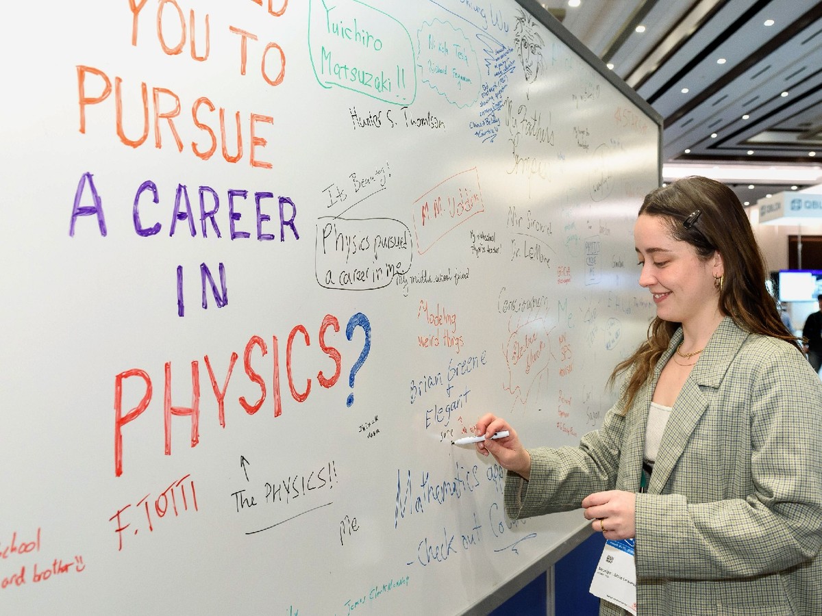 A woman writes on a white board