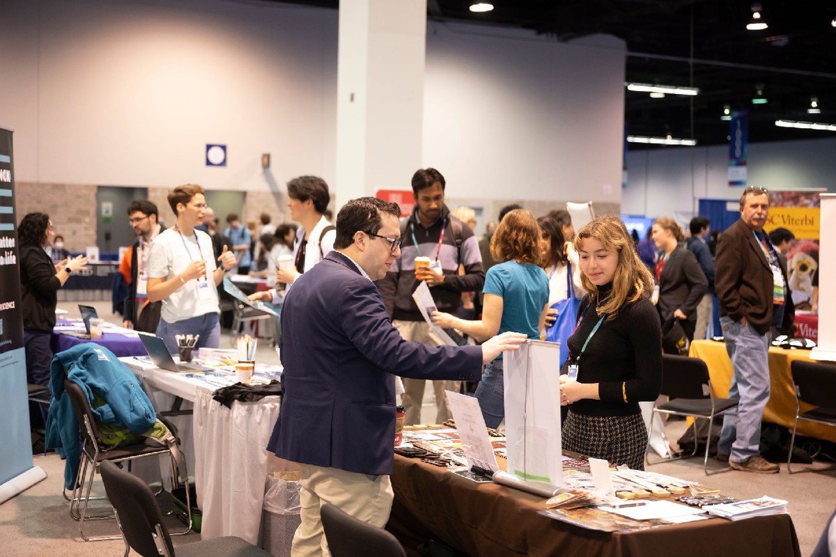 Exhibitors interacting with students at an APS meeting