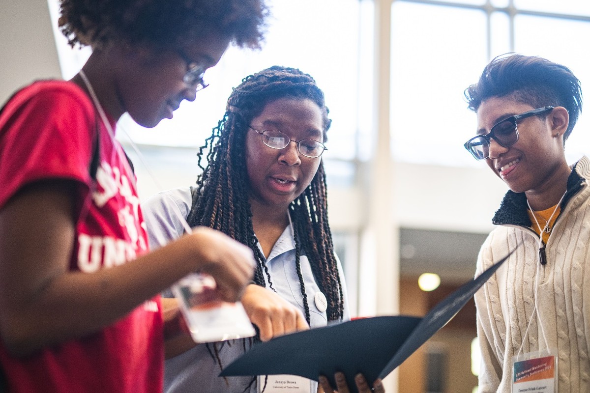 A mentor speaking with two students