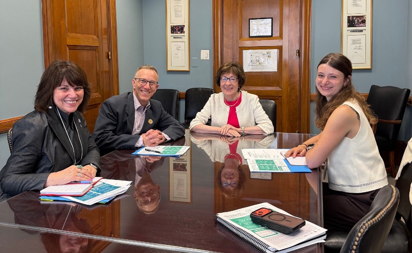 Three coalition members are seated at a table with Senator Susan Collins.