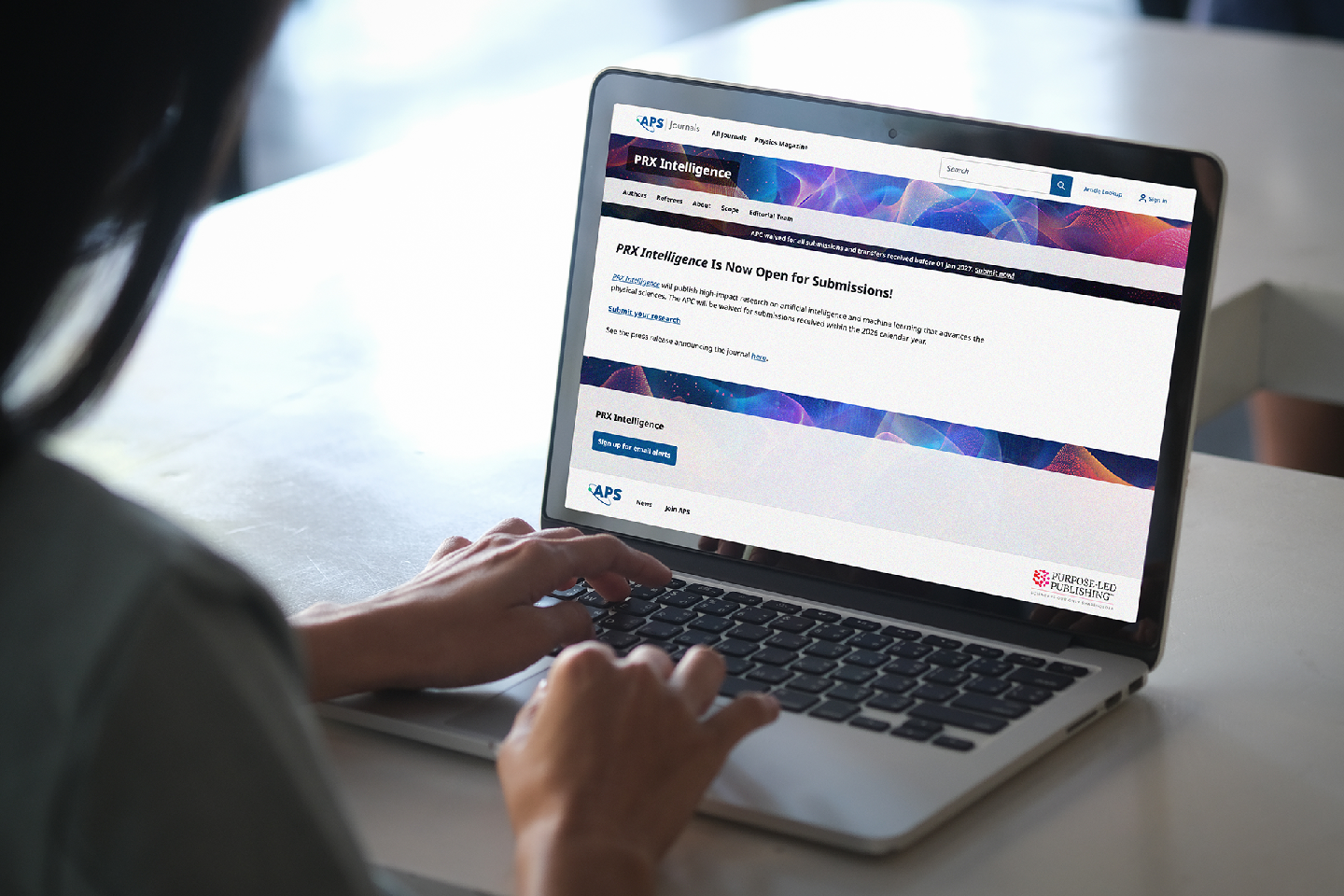 A woman looks on her screen which showing the PRX Intelligence journals website.