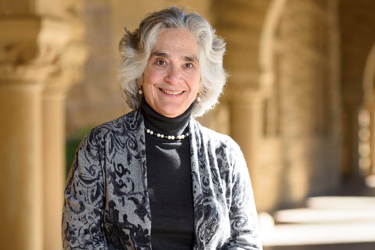 A head shot of Drell, standing outside in front of columns on the Stanford campus.