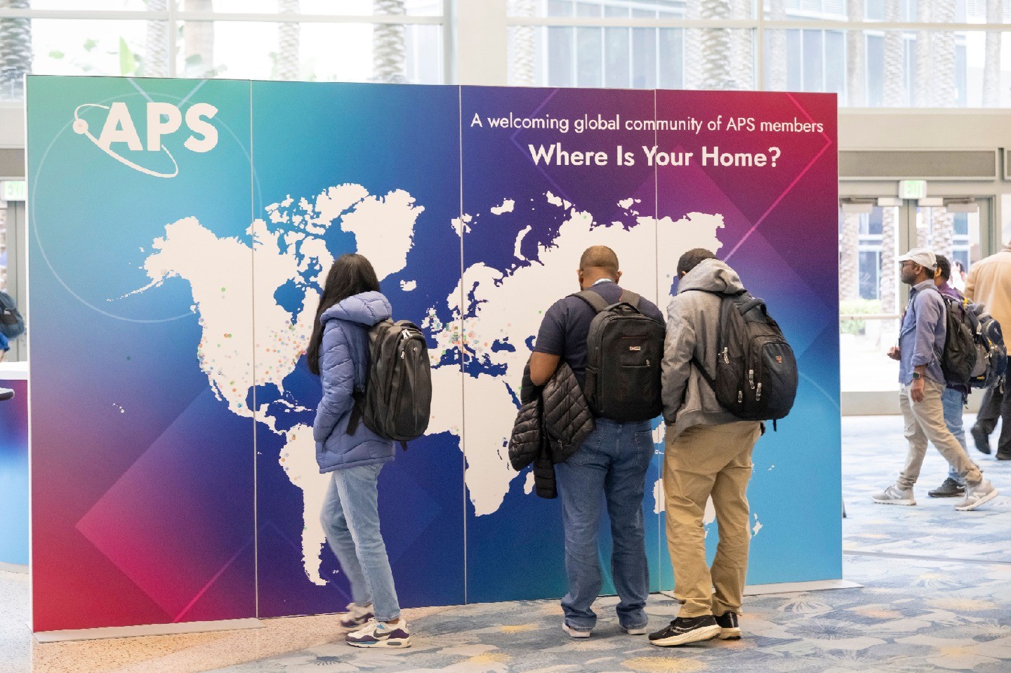 Students looking at a world map at the APS Global Physics Summit