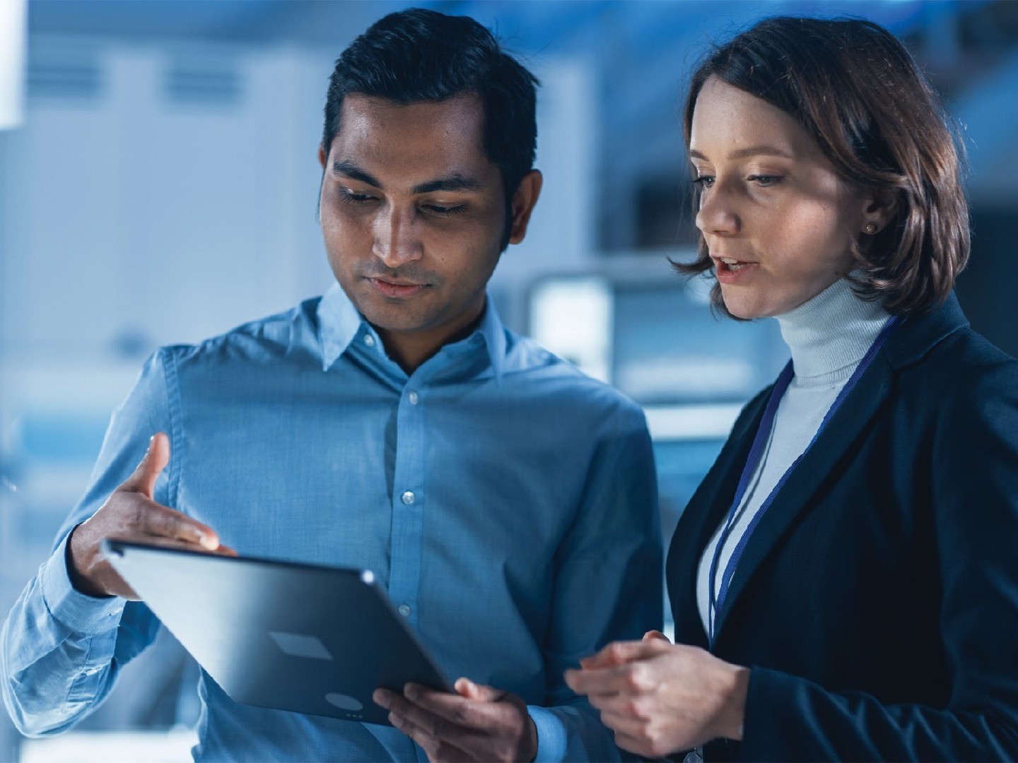 A Southeast Asian man and a white woman looking at a tablet