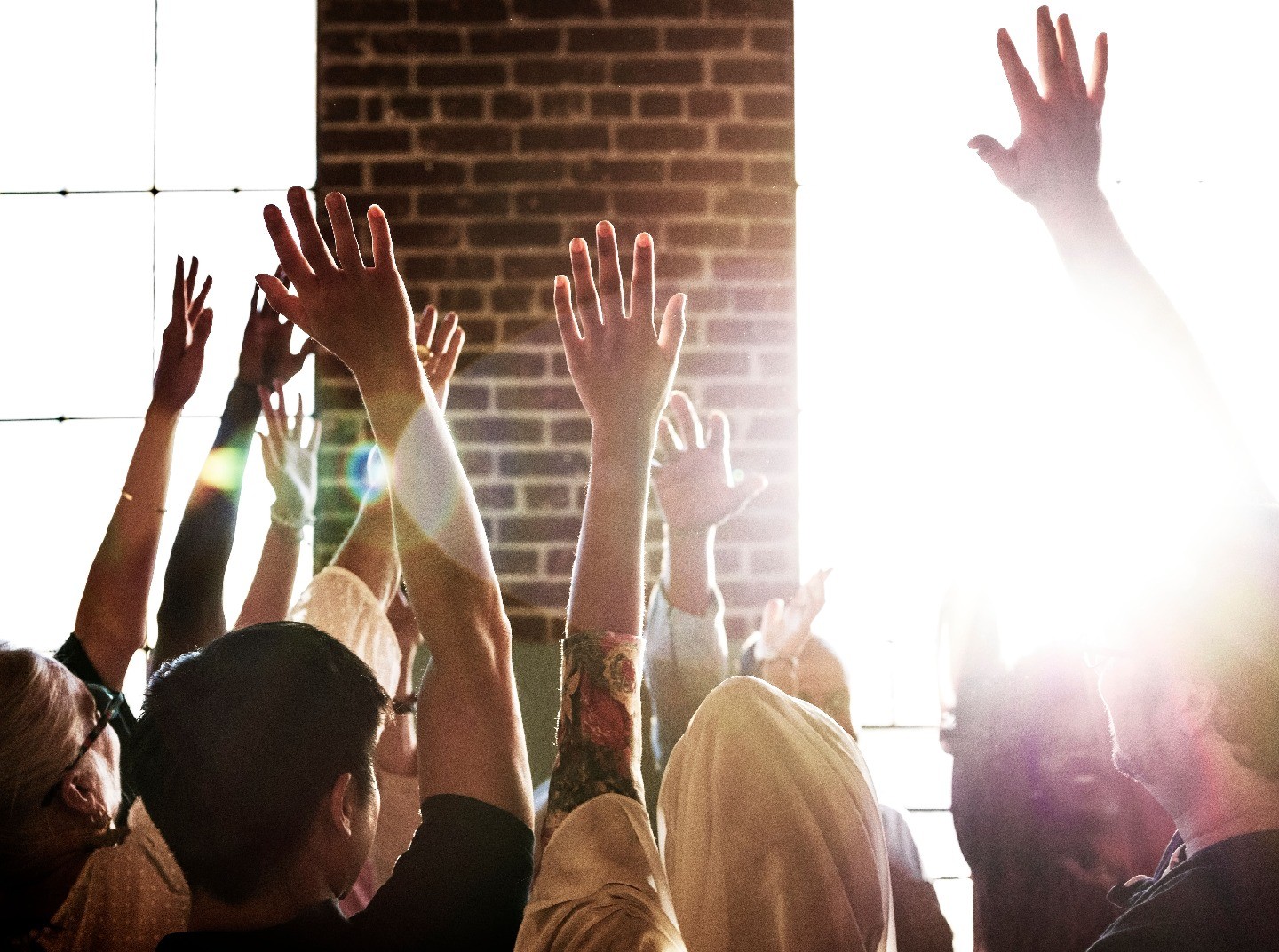 People in a meeting raising their hands