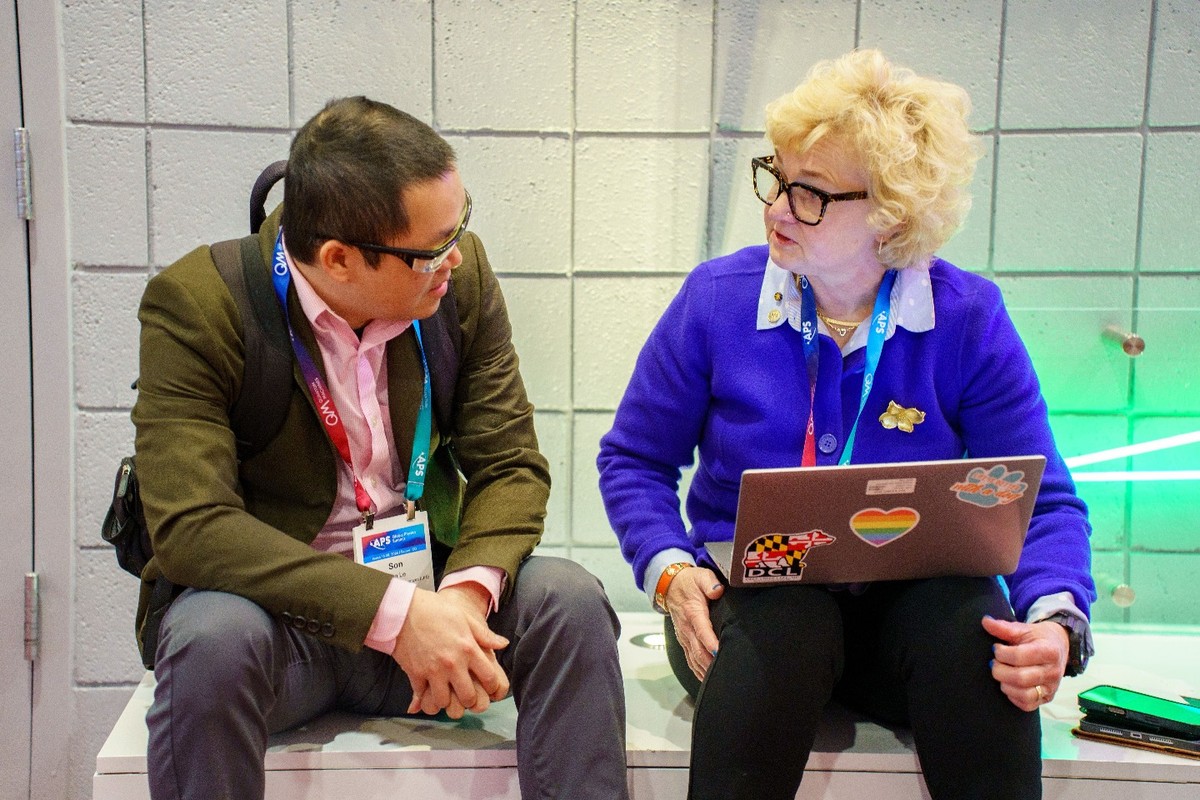 Two people having a discussion around a laptop