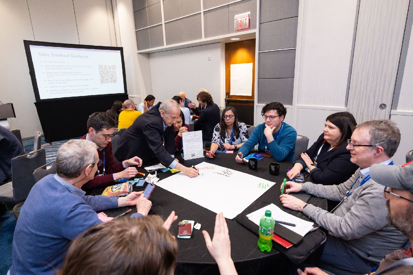 A group of physicists sitting around a table and collaborating in a brainstorming session