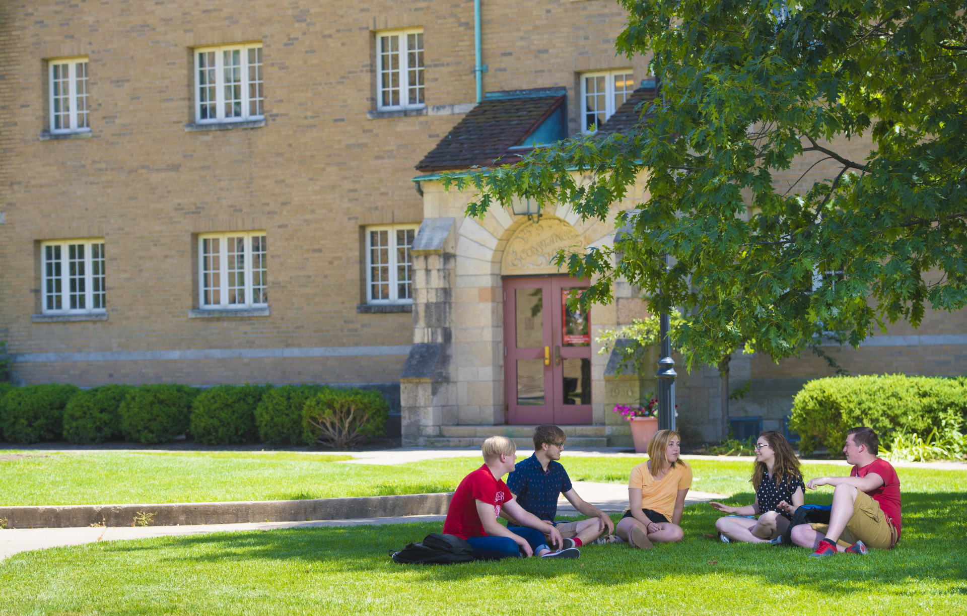 A group of college students sits on the campus at Bradley University.