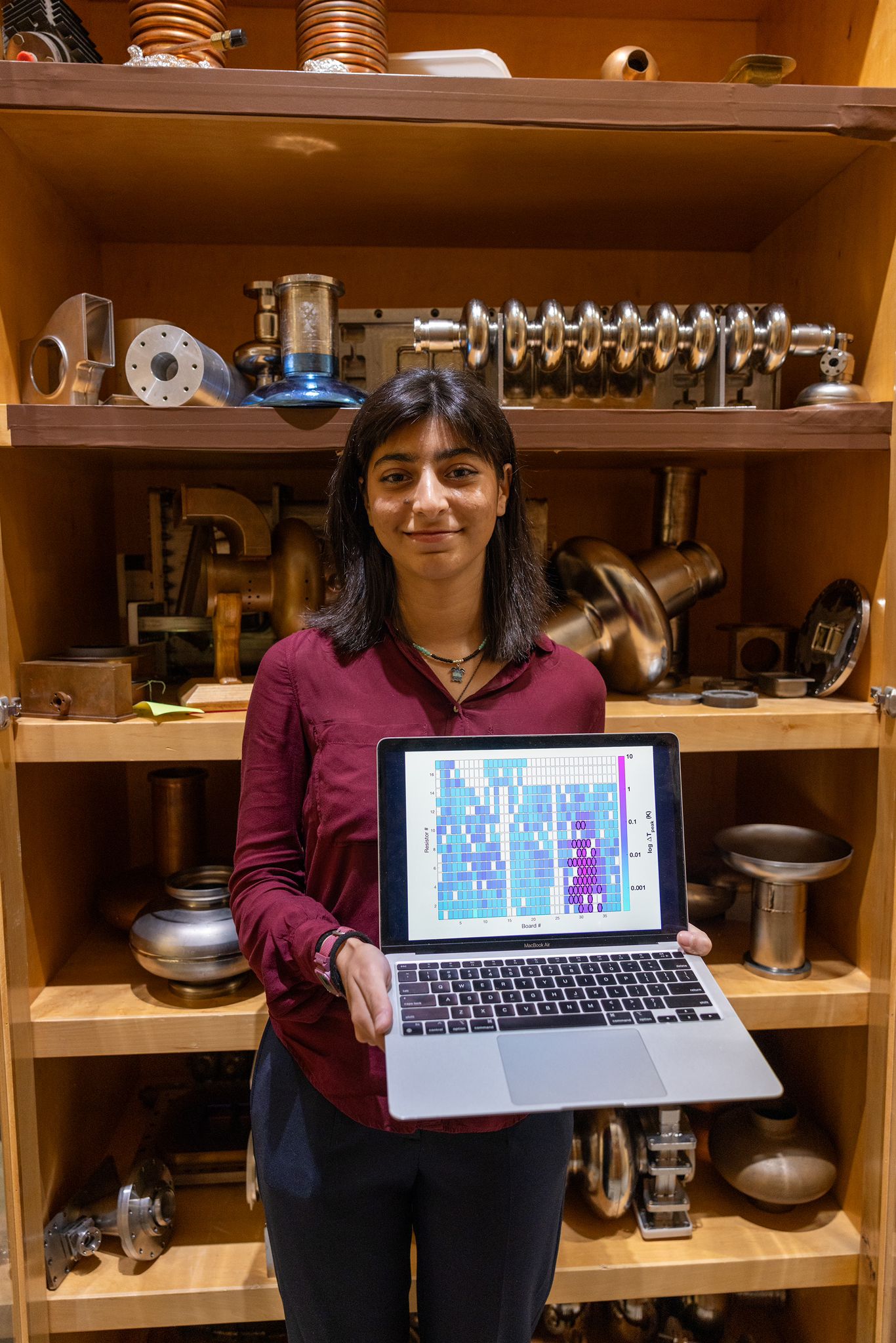Irfan stands in front of a shelf holding a computer