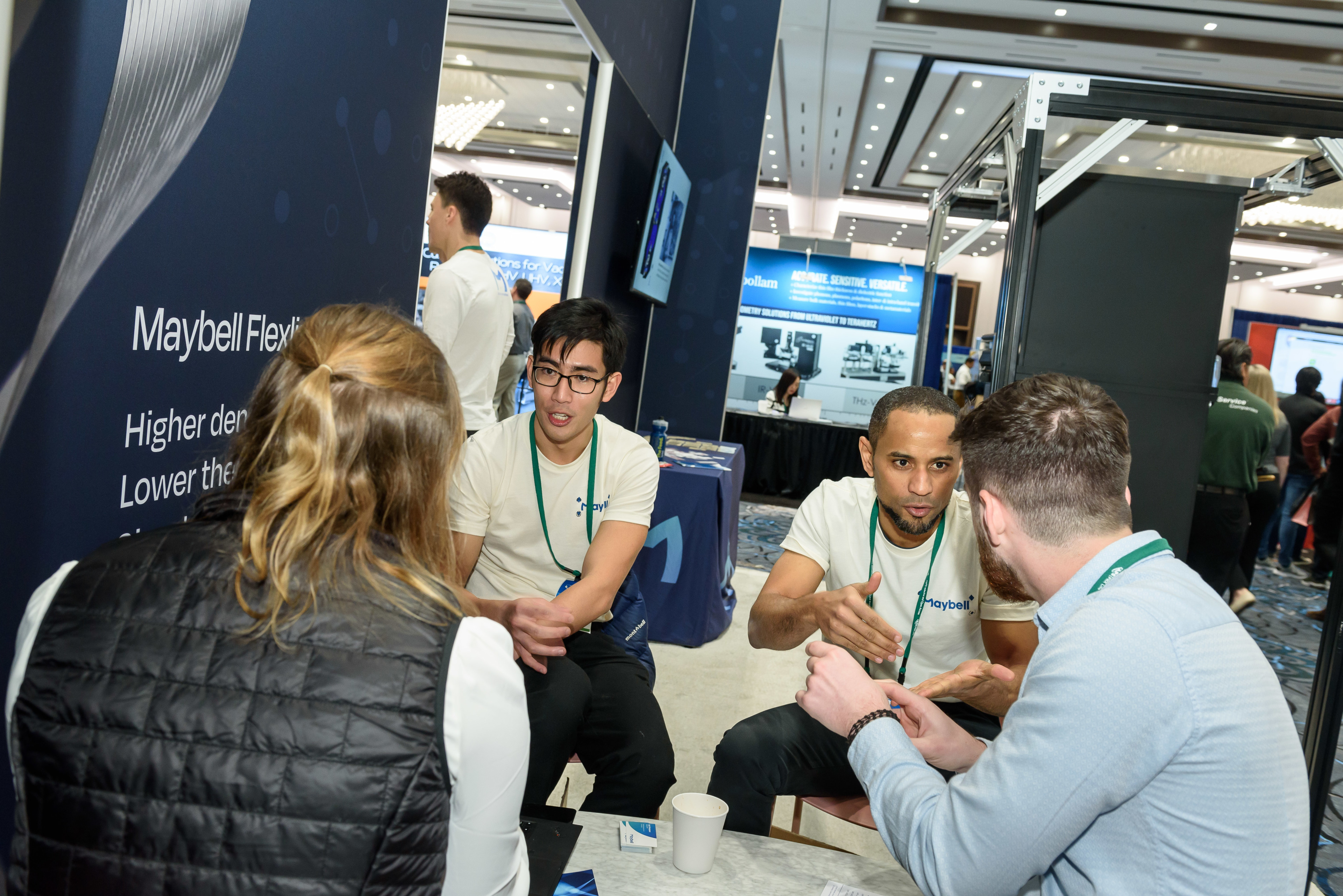 People talking around a table at the APS March Meeting 2023 exhibit hall